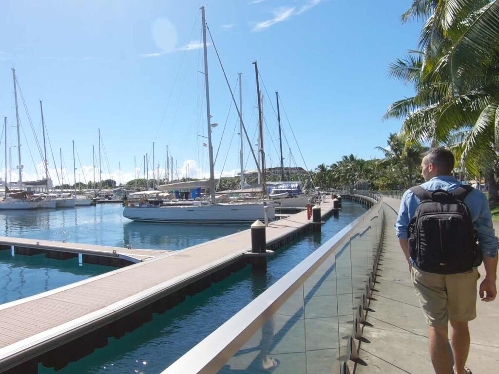 Balade le long du front de mer de Papeete, Tahiti, avec vue sur le lagon, les voiliers et les montagnes en arrière-plan.