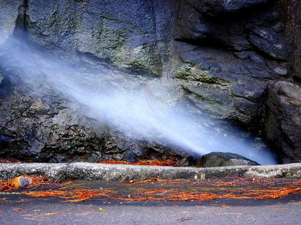 Le Trou du Souffleur d'Arahoho à Tahiti, une formation naturelle spectaculaire où les vagues s’engouffrent dans la roche pour créer un puissant jet d’eau.