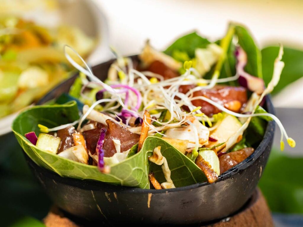 Plat typique polynésien avec poisson cru et accompagnements au restaurant Chez Rua à Rangiroa.