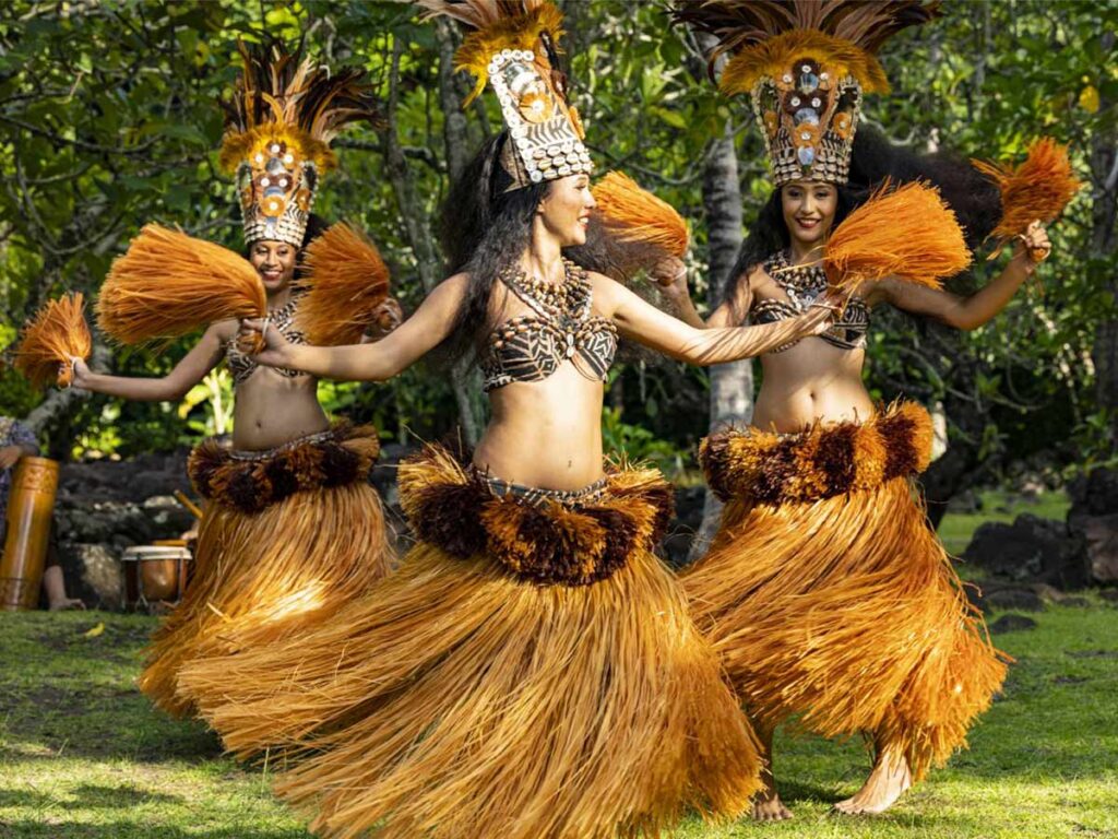 Danseuses polynésiennes exécutant une danse traditionnelle en tenue colorée, célébrant la culture de Polynésie française.