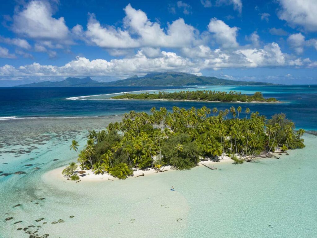 Vue idyllique du Motu Céran à Taha’a, avec son sable blanc, son lagon turquoise et sa végétation luxuriante.