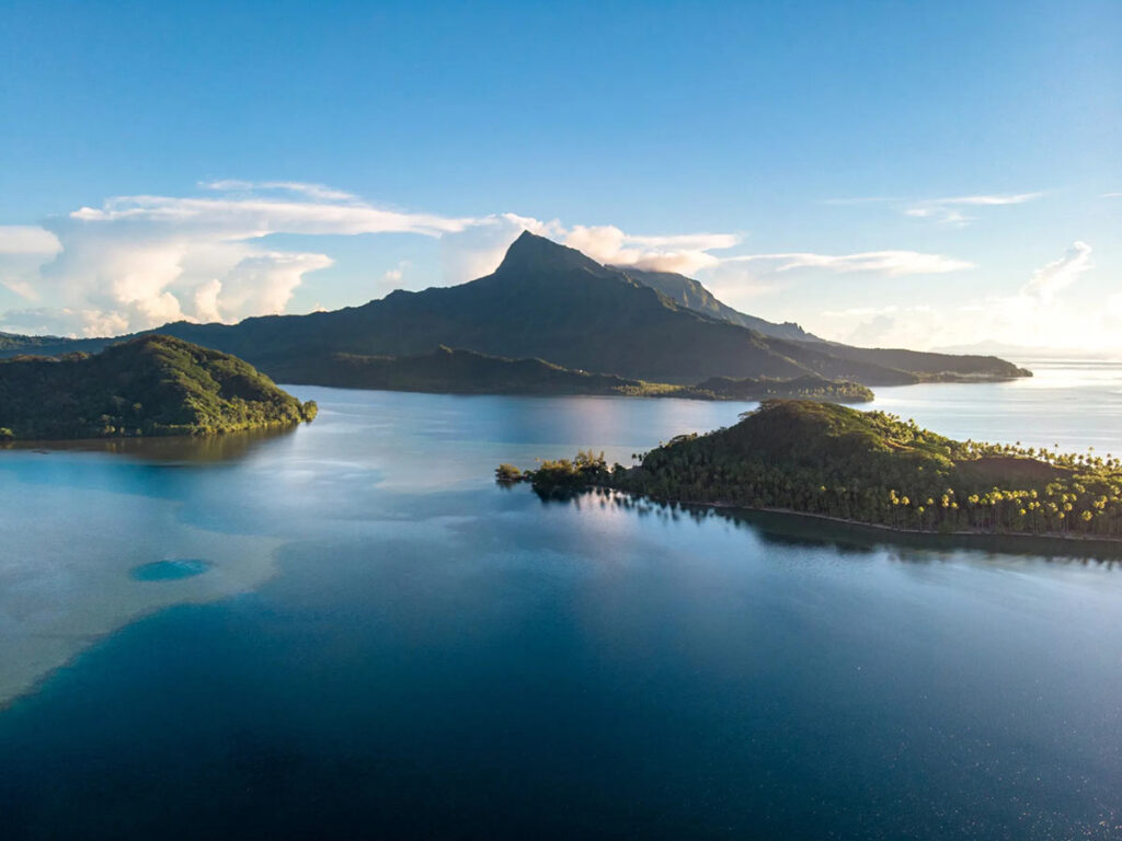 Vue aérienne de Raiatea en Polynésie française, révélant son lagon turquoise, ses montagnes verdoyantes et ses motus idylliques, cœur spirituel des îles Sous-le-Vent.