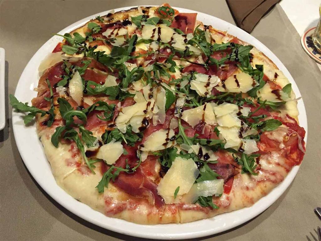 Pizza servie dans une assiette au restaurant The Lucky House - Fare Manuia à Bora Bora.